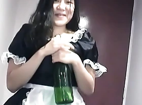 Young Asian girl dressed as a maid indulges herself with a fiasco of sparkling burgundy on camera for you